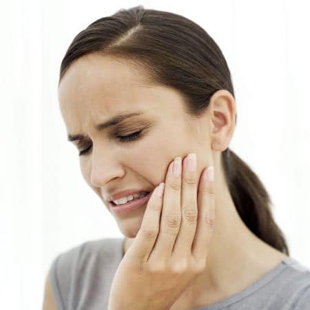 donna con dente spezzato e dolore
