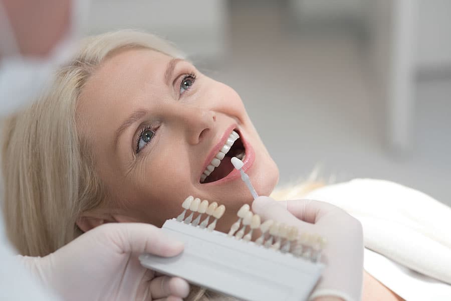 dentista mette le faccette dentali per correggere un malposizionamento